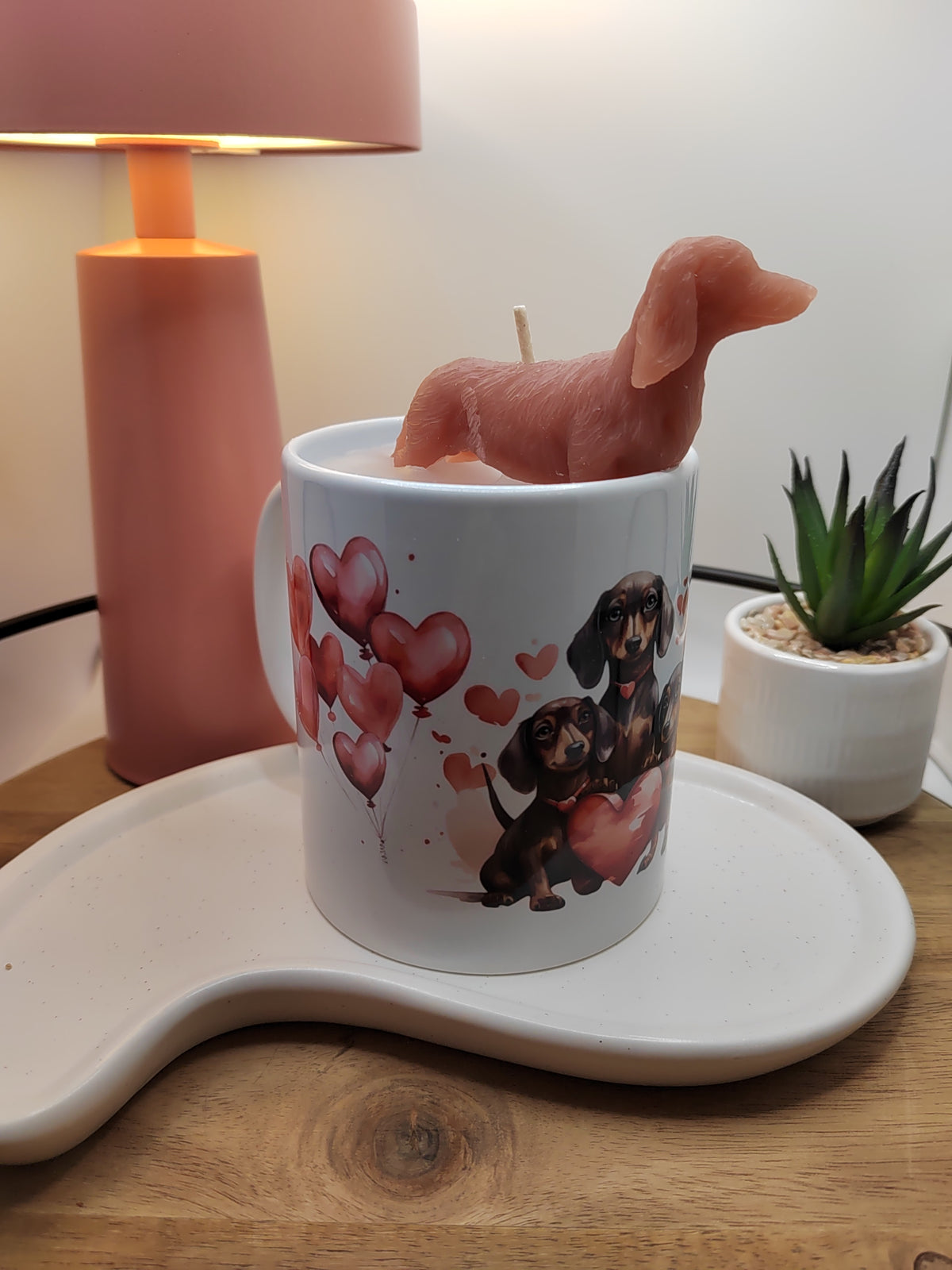 Handgegossene Kerze in Dackel-Tasse mit roter Wachsfigur im Seitenprofil