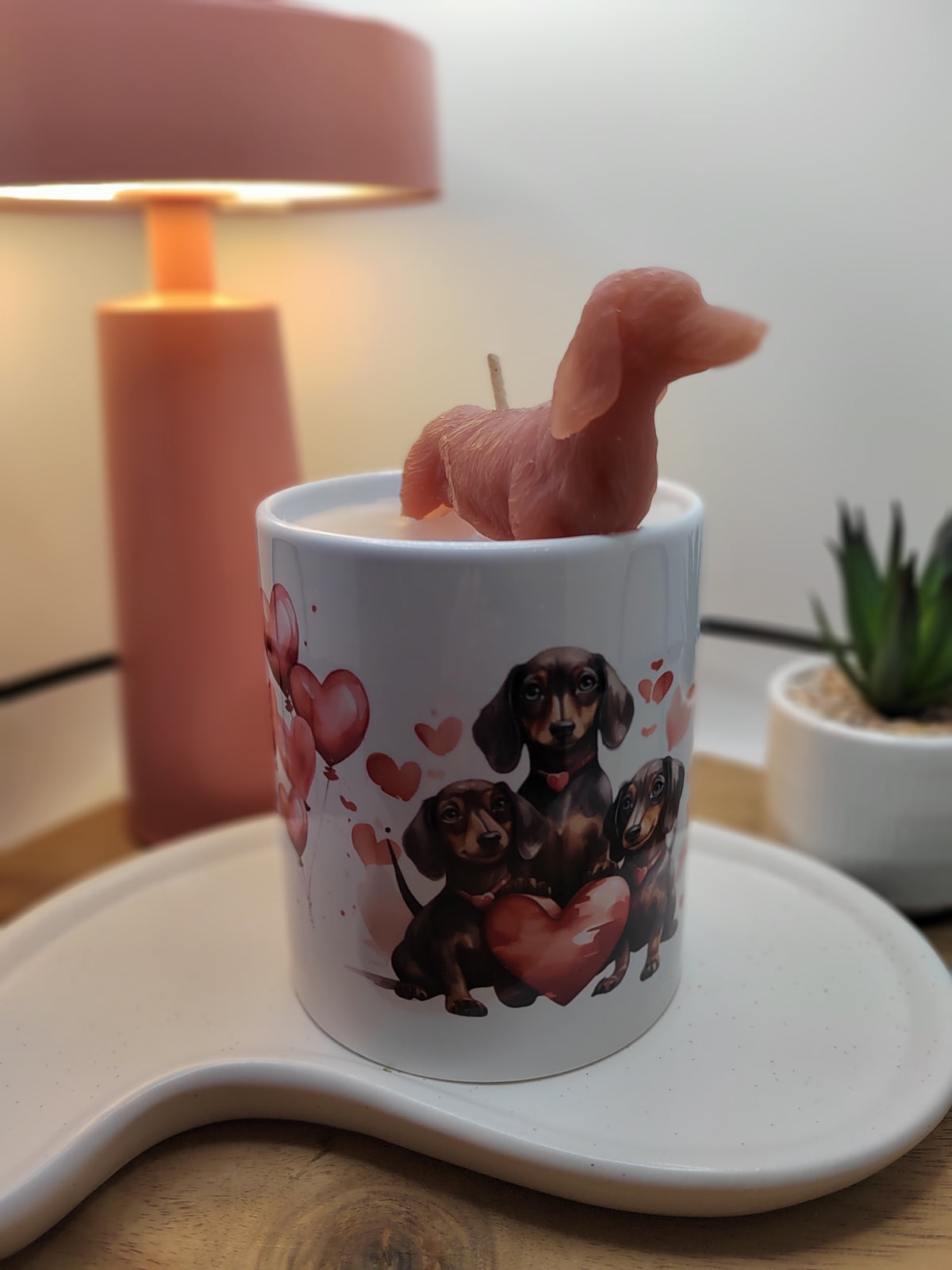 Nahaufnahme der Dackel-Tasse mit roter Wachsfigur und drei Hunden mit Herz