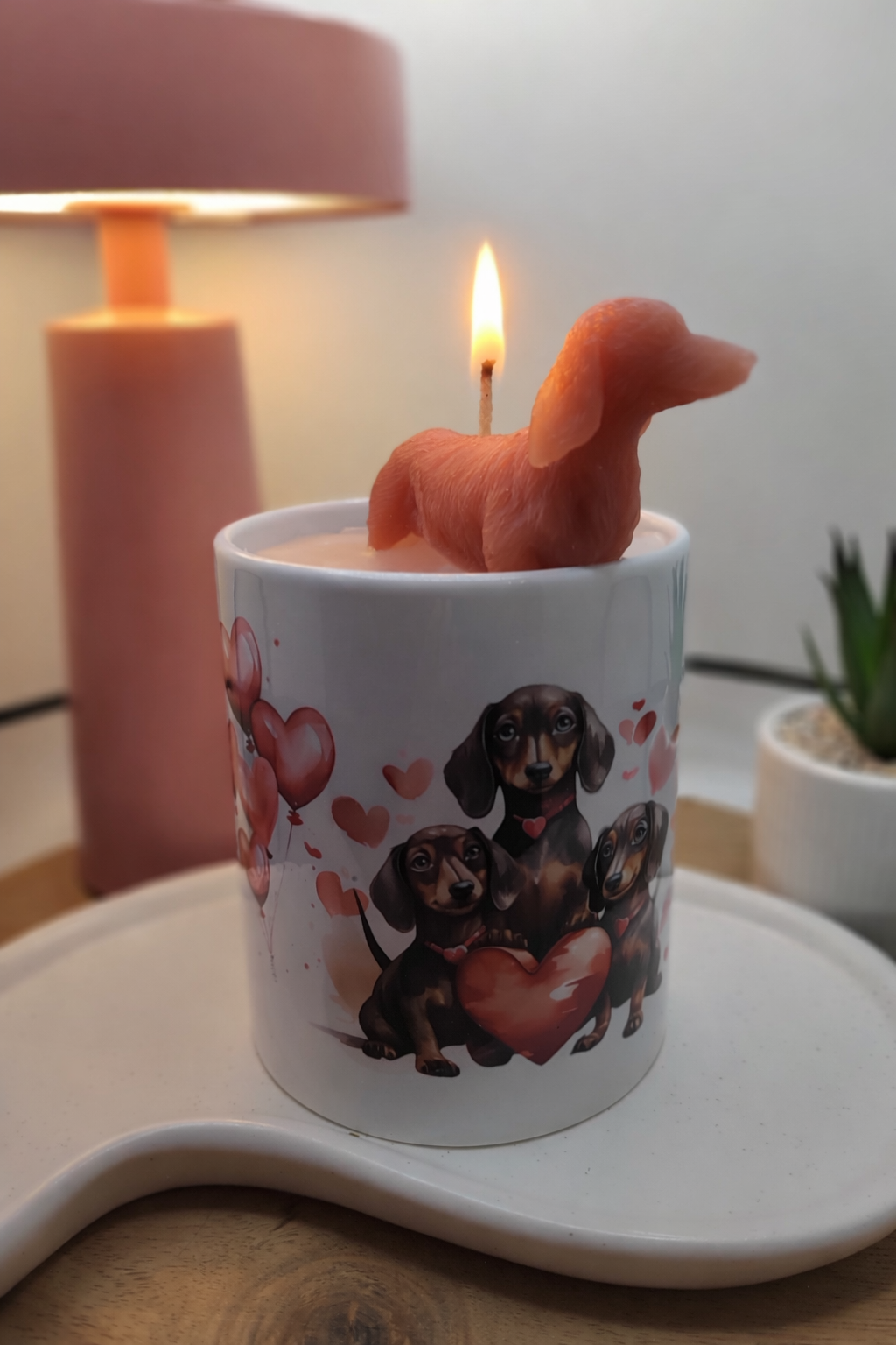 Brennende Dackel-Kerze in weißer Keramiktasse mit Herzmotiv und roter Wachsfigur