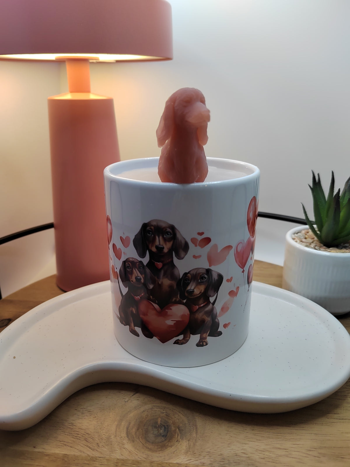 Dackel-Kerze mit frontal ausgerichteter roter Wachsfigur und Hundemotiv auf der Tasse