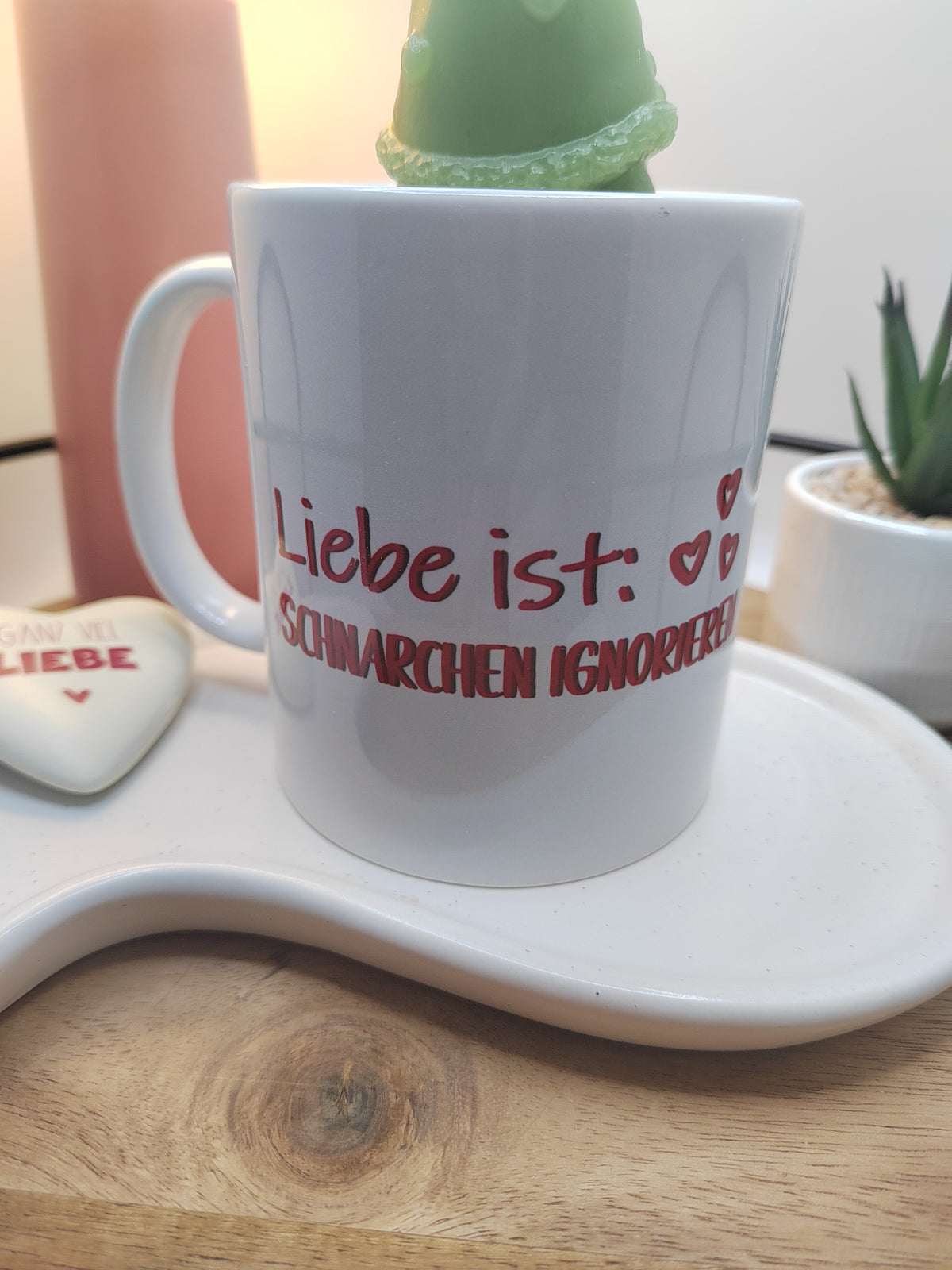 Nahaufnahme der Tasse mit dem Spruch „Liebe ist: Schnarchen ignorieren“ und grünem Wichtel