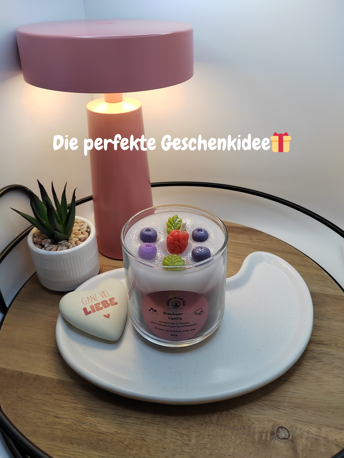 Blaubeer-Vanille-Duftkerze im Glas als dekorative Geschenkidee auf einem weißen Tablett