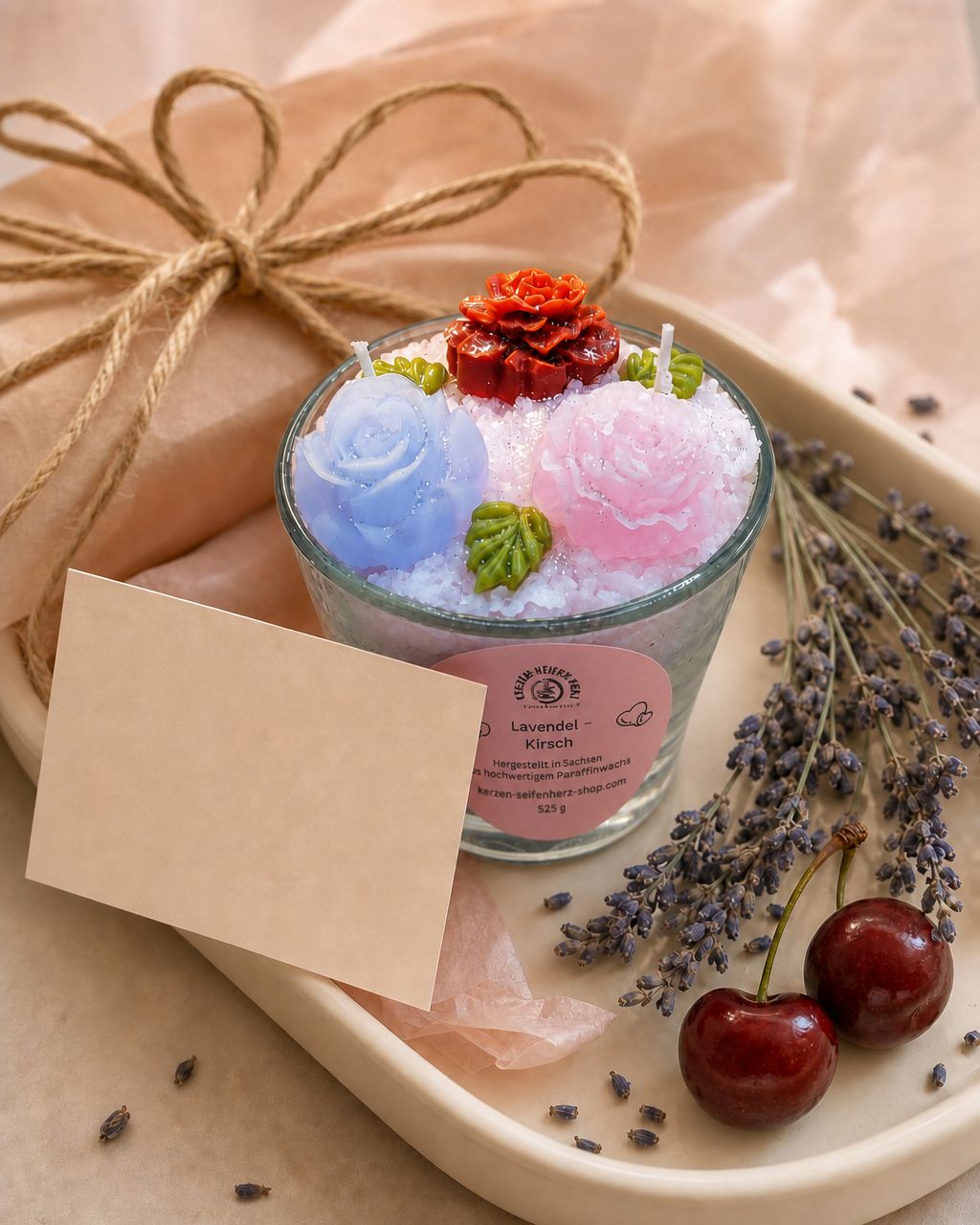 Lavendel-Kirsch Duftkerze auf Geschenkpapier mit leerer Grußkarte, Lavendel und Kirschen