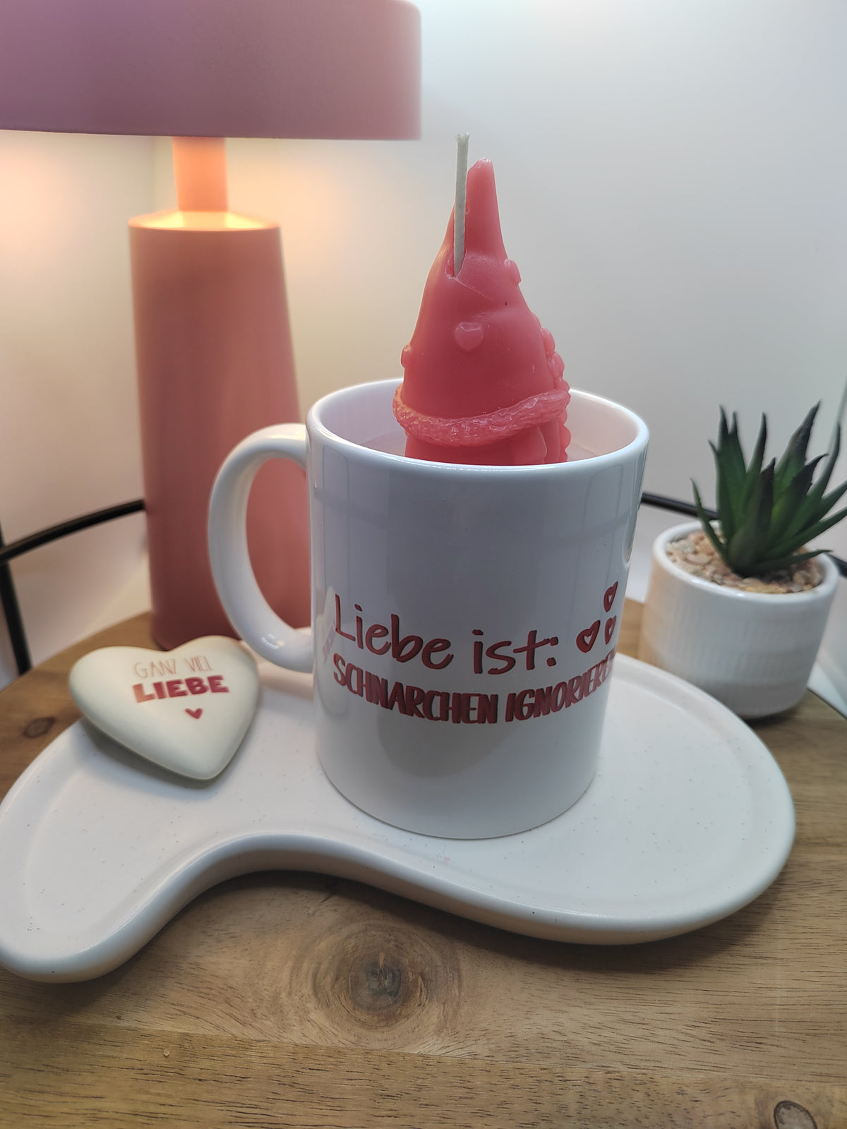Kerze in weißer Tasse mit rotem Wichtel und seitlicher Ansicht des Spruches