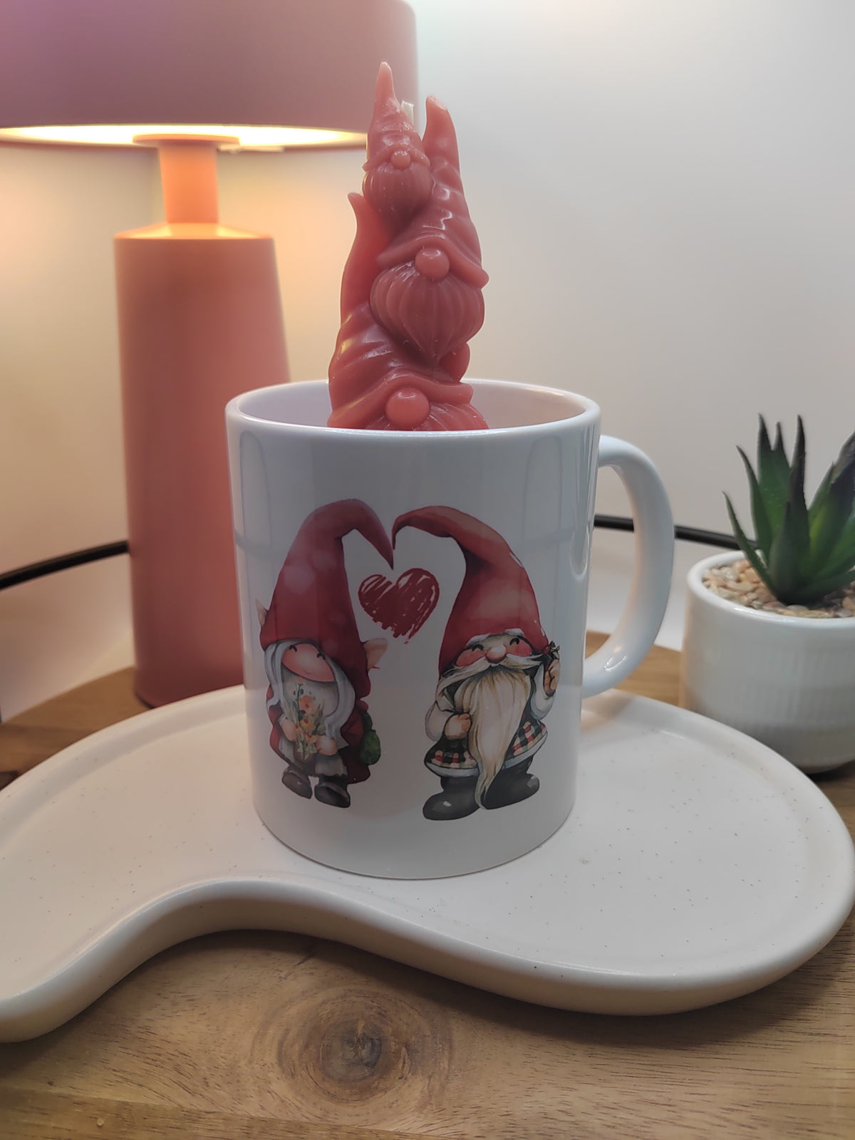Nahaufnahme der roten Wichtelfamilie aus Wachs auf der „Be Mine“-Kerze in der Keramiktasse