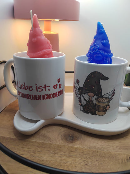 Zwei Kerzen in Tassen mit rotem und blauem Wichtel sowie humorvollem Spruch und Motiv