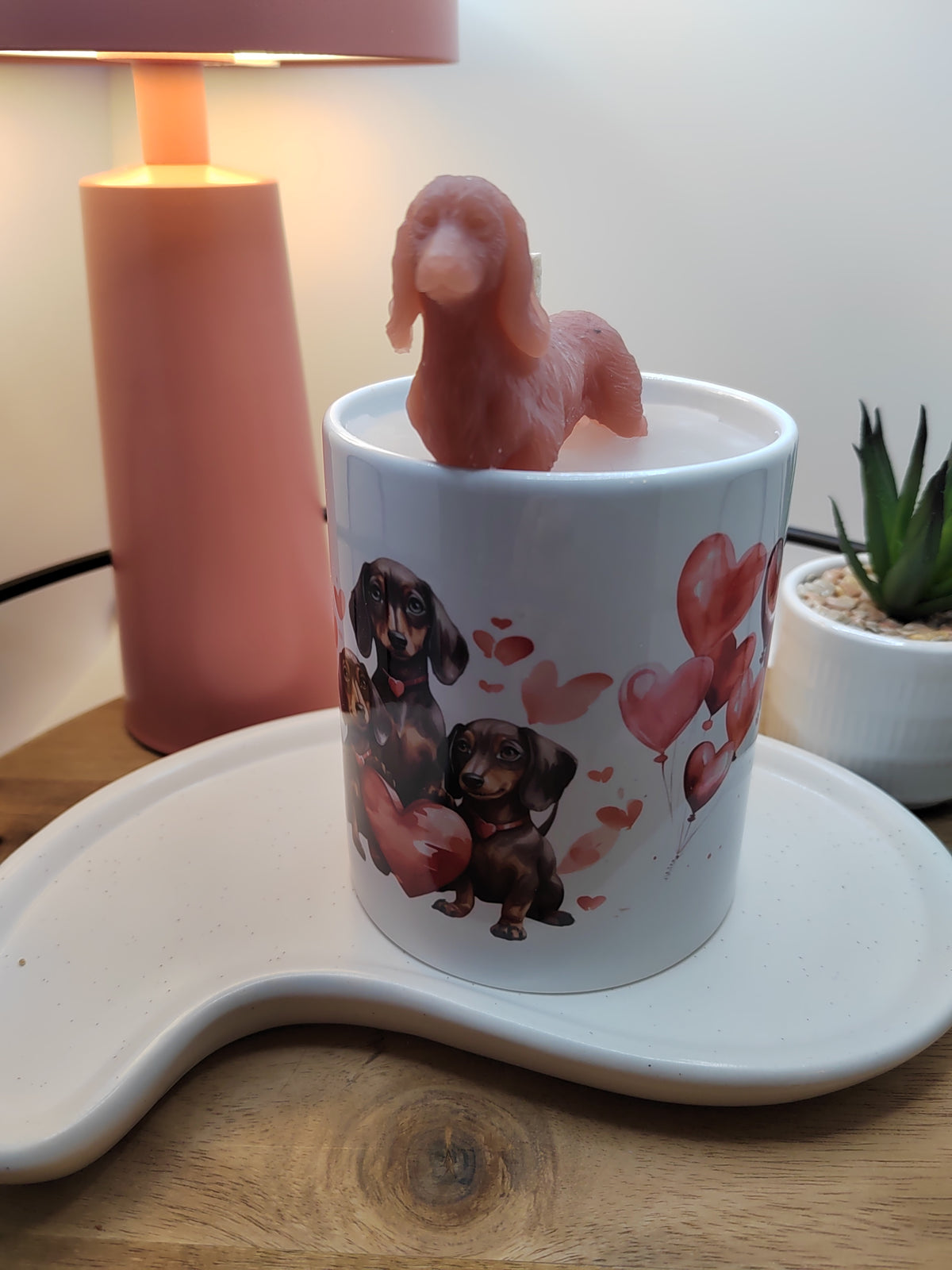 Weiße Keramiktasse mit Dackelmotiv und roter Wachsfigur in frontaler Ansicht