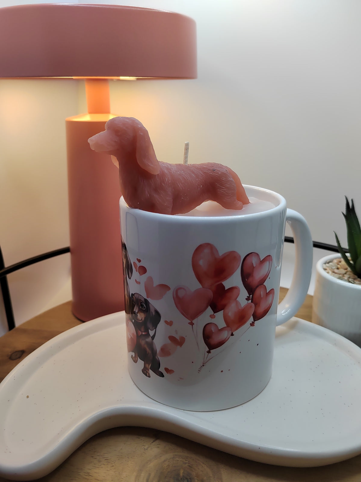 Dackel-Kerze in weißer Tasse mit Herzballons und seitlich sichtbarem Henkel