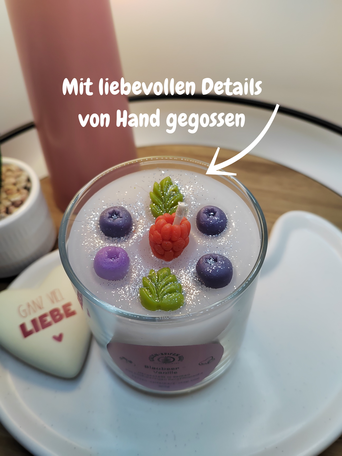 Nahaufnahme der handgegossenen Blaubeer-Vanille-Duftkerze mit Beeren- und Blatt-Dekoration